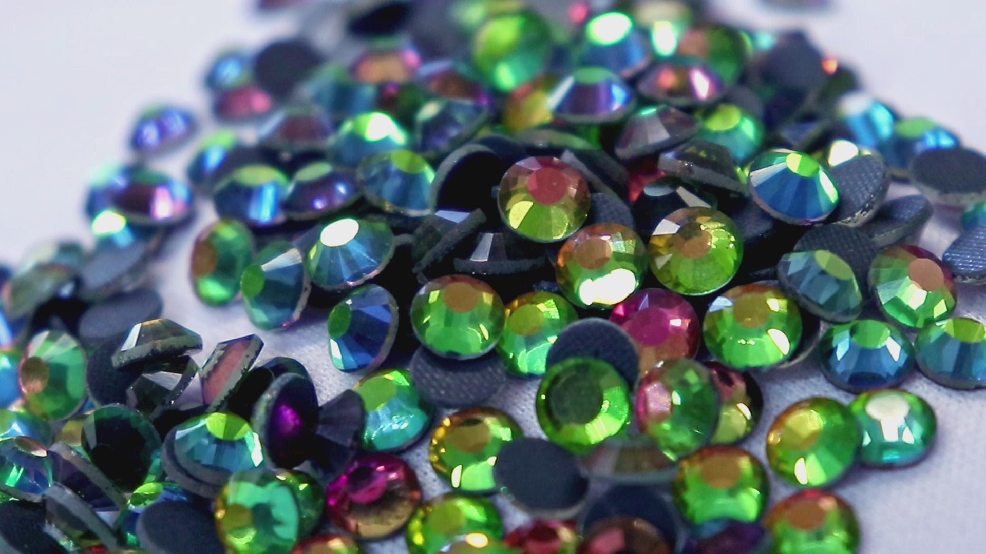 Load video: a selection of colourful rhinestones fall into view.